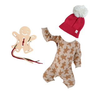 Baby onesie with gingerbread pattern, red hat with white pom-pom, and wooden gingerbread man toy at Design Life Kids